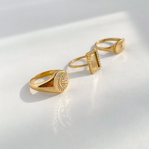 Detailed view of three celestial gold rings with moon, star motifs and crystal inlay