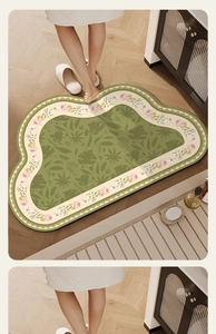 Close-up of cloud-shaped green bathroom mat featuring floral patterns and soft texture