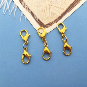 Three gold double-ended lobster clasps for jewelry making on a light blue background