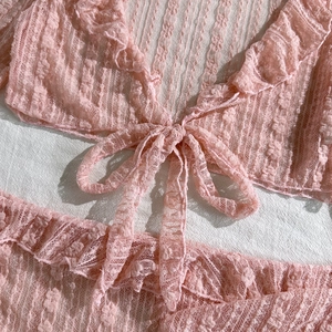 Close-up of pink lace bikini set with delicate floral patterns and ruffled edges