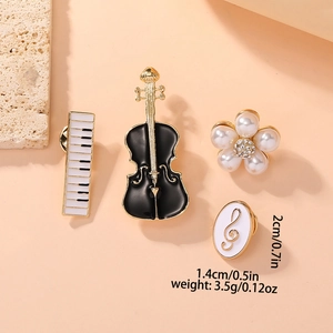 Detailed view of musical brooch set with violin, piano and pearl flower in gold and enamel