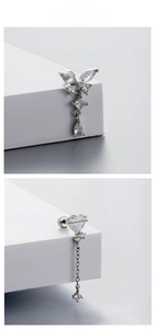 Detail of silver titanium steel earrings with butterfly heart charms and drop pendants