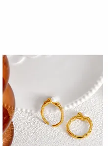 Close-up of golden vintage rings with white pearls and branch-like texture on a plate