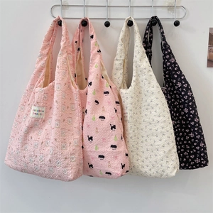 Detail of bubble texture fabric tote bags in pink, white, black and floral patterns