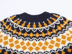 Detailed close-up of navy blue knit sweater neckline with white and mustard geometric patterns