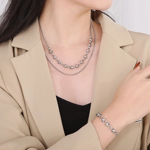 Silver double-layer butterfly chain necklace and bracelet set shown on a model