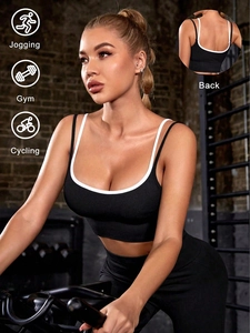Detail of black sports bra with white piping and criss-cross back for gym workout