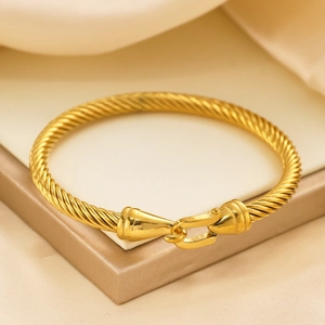Detailed close-up of the 18k gold plated twisted rope bracelet with a horseshoe buckle