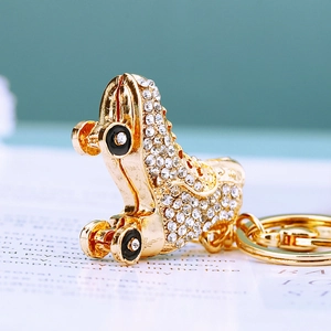 Macro shot of gold-tone metal ice skate keychain with sparkling rhinestones and rotating wheels
