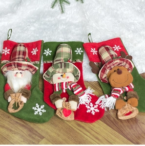 Close-up of 3D Santa, snowman and reindeer Christmas stockings with red and green patchwork