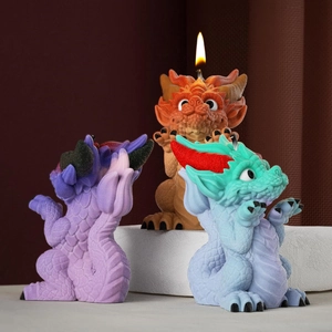 Tres velas aromáticas de dragones coloridos con textura de escamas sobre una base redonda