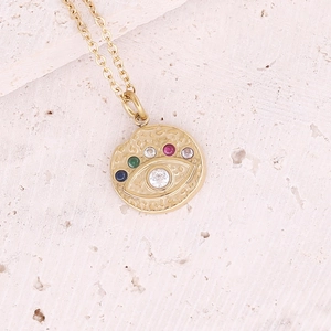 Golden necklace featuring a hammered round pendant with a colorful zircon evil eye design