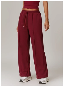 Detail of high-waisted burgundy wide-leg joggers with elastic drawstring and center seam