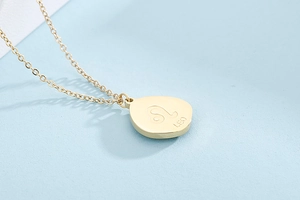 Macro shot of gold constellation necklace featuring an engraved Leo sign pendant