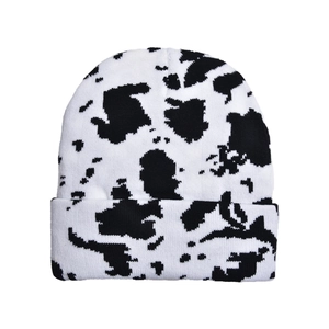 Close-up of black and white cow print knit beanie with soft textured fabric detail
