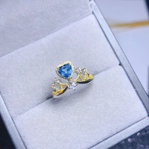 Detail-Makroaufnahme eines herzförmigen blauen Edelsteinrings mit Kronendesign auf Samt