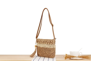 Détail du sac bandoulière en paille tressé main avec glands en perles de bois