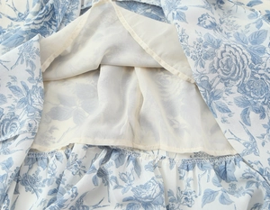 Detailed macro view of white floral dress featuring double lining and blue print