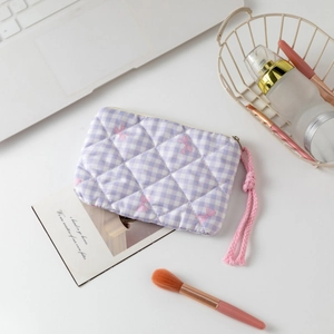 Macro shot of quilted lilac checkered makeup bag with bow pattern and zip detail