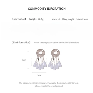 Detail view of silver tassel earrings with diamond accents and material specifications