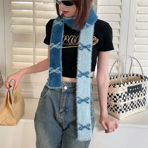 Detail of soft blue gradient fuzzy scarf featuring a navy bow pattern and plush texture