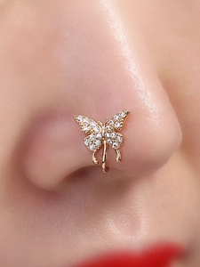 Elegant gold butterfly nose clip with sparkling diamonds shown on a model model