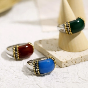 Detailed view of vintage rings with green red and blue gemstones on stone display