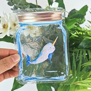 Rainbow prism suncatcher window decal featuring a cartoon narwhal in a mason jar pouch