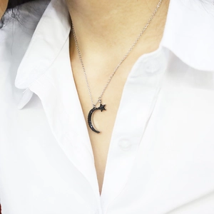 Detail view of starry moon pendant necklace featuring black pavé crystals on silver chain