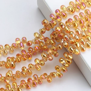 Macro detail of amber iridescent teardrop glass beads for DIY jewelry making and crafts