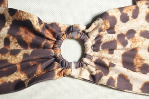 Détail du haut de bikini léopard avec anneau décoratif et tissu en maille élastique