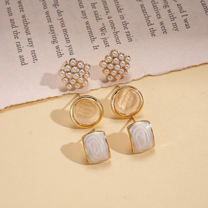Détails de boucles d'oreilles avec perles, œil de chat et nacre sur monture dorée