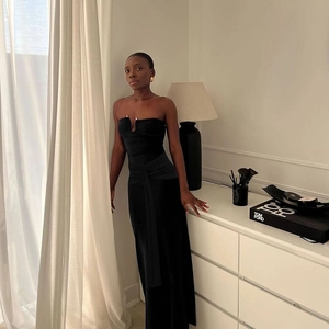 Detail of elegant black strapless midi dress with V-neckline and pleated bodice design