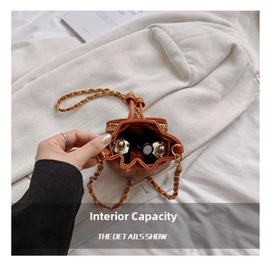 Interior capacity display of brown drawstring mini bucket bag with leather chain strap