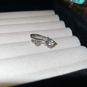Vue macro d'un earcuff argenté double rang avec deux cristaux étincelants dans son écrin