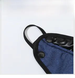 Detail of blue denim winter hat featuring adjustable snap buttons and reinforced edges