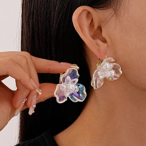 Detail of sweet iridescent resin flower earrings with beaded center and gold-tone hooks
