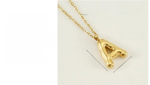 Vue macro d'un pendentif lettre A dorée en acier inoxydable poli avec placage 18K PVD