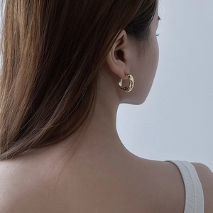 Minimalist gold irregular geometric ripple hoop earrings with a metallic liquid texture