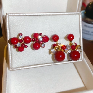 Macro shot of red zircon firework earrings in gold plating and sterling silver needles