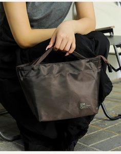 Dettaglio della borsa termica marrone scuro impermeabile con logo e manico portatile
