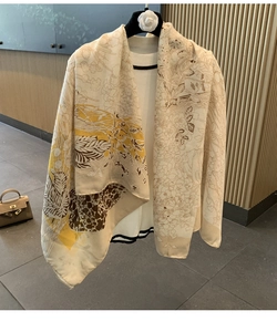 Detail of a lightweight cotton-linen beige shawl with floral print on an elegant hanger