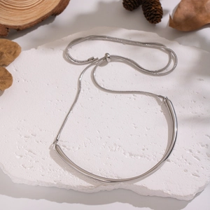 Détail d'un pendentif tube courbé argenté avec chaîne serpent sur pierre naturelle