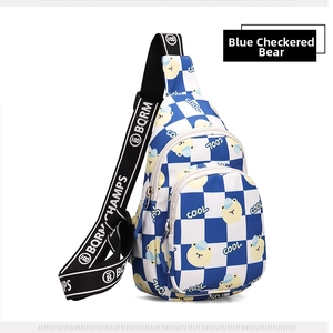 Close-up of blue checkered kid's chest bag with cartoon bear and adjustable strap