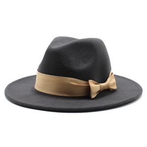 Dark grey wool fedora hat with a golden brown satin ribbon bow on white background