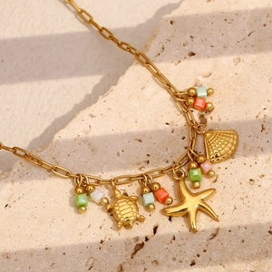Collier en acier plaqué or 18K avec pendentifs coquillage, tortue et étoile de mer