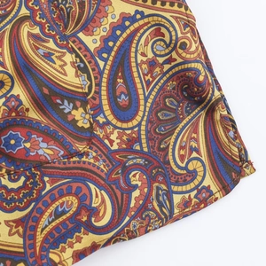 Detailed view of yellow paisley print fabric with high-quality edge stitching craftsmanship