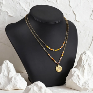 Bohemian layered gold necklace with colorful turquoise beads and a celestial sun pendant