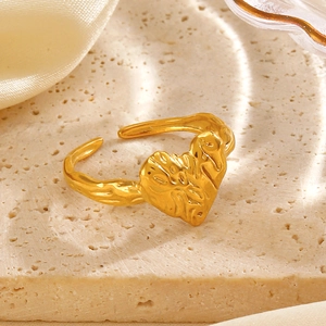 Minimalist gold heart-shaped open ring featuring a unique lava texture on stone surface