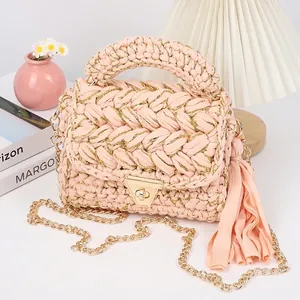 Detail of pink handmade crochet bag with golden clasp and long decorative tassels